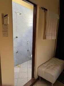 a bathroom with a shower and a stool with a glass door at AMTWAPA 2 bedroom pure blissful apartment ready to accommodate you and your family friends or colleagues in Mtwapa