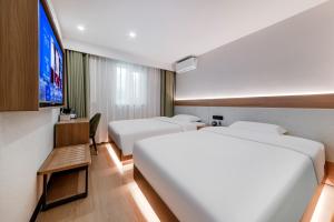 a hotel room with two beds and a flat screen tv at An Yi Hotel in Beijing