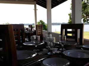 a table with glasses and plates on top of it at Naaval Hotel in Batticaloa