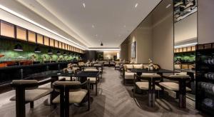 un restaurant avec des tables et des tabourets dans une salle dans l'établissement Borrman Hotel Guangzhou Tianhe Sports Center Linhexi Metro Station, à Canton