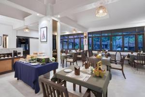 ein Esszimmer mit Tischen und Stühlen und Fenstern in der Unterkunft B2 Suthep Night Market Premier Resort in Chiang Mai