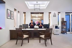 zwei Frauen stehen an der Rezeption in einem Büro in der Unterkunft B2 Suthep Night Market Premier Resort in Chiang Mai + 235 Fotos