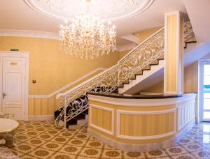 a staircase in a room with a chandelier at Hotel Grand Aristocrate in Dubovtsy