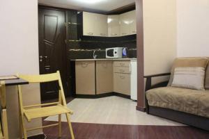 リヴィウにあるOhiienka Apartmentのキッチン、ベッド1台、椅子が備わる小さな客室です。