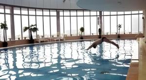 a person in a swimming pool in a building at Zaozhuang Hotel in Zaozhuang