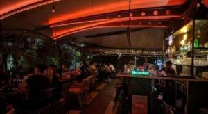 a group of people sitting at a bar in a restaurant at ZUZU Simpang Lima in Semarang