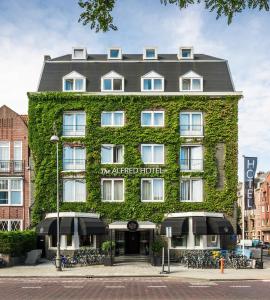 a building covered in ivy with the aligned hotel at The Alfred Hotel in Amsterdam
