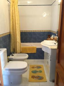 a bathroom with a toilet and a sink and a tub at Ericeira Lovers Apartment Center in Ericeira