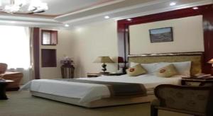 a bedroom with a large white bed and a couch at Wutaishan Wufeng Hotel in Wutai