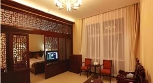 a living room with a television and a bedroom at Wutaishan Wufeng Hotel in Wutai