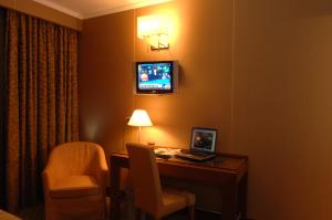 a hotel room with a desk with a laptop and a television at Hotel Liola' in Castrocielo