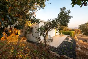 a white house with a patio and trees at Shifon Ein Zivan in Ein Zivan