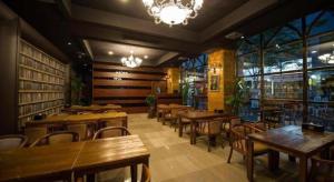 a restaurant with wooden tables and chairs and windows at Hotel Floce in Pup'yŏng-dong