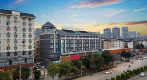 eine Stadt mit Gebäuden und eine Straße mit Autos in der Unterkunft City Comfort Inn Baise Uprising Memorial Park Laiyu in Qitang