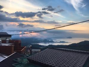 a view from the roof of a house with a sunset at Easy B&B in Jiufen