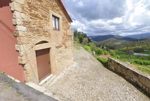 a stone building with a door on the side of it at Casinha Pousafoles in Arouca