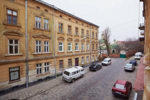 una strada con auto parcheggiate di fronte a un edificio di Pylnykarska 6 a Lviv