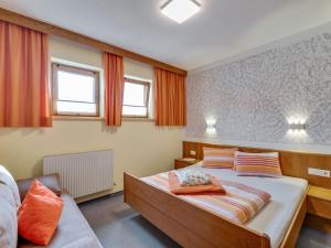 a bedroom with a large bed with orange curtains at Apartment in Fiss near Ski Lifts in Fiss