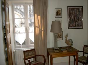Habitación con ventana y mesa con lámpara. en Maison Lépie en Beurlay