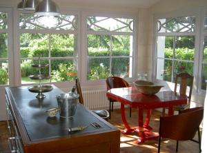 Maison Lépie في Beurlay: مطبخ مع طاولة وكراسي ونوافذ