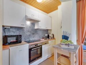 a kitchen with white cabinets and a table with a microwave at Apartment in Fiss near Ski Lifts in Fiss +18 photos