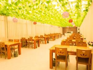 阜陽にあるGreenTree Inn Fuyang Yijing International North Businessの木製のテーブルと椅子のあるダイニングルーム
