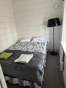una camera con un letto in una stanza con una lampada di Semesterlägenheter 150m till Vänern ad Åmål