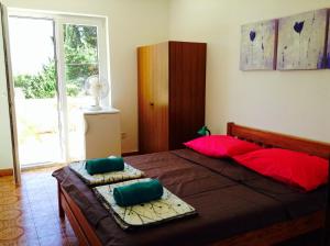 a bedroom with a large bed with red and green pillows at Guest house Perfect Location in Bol