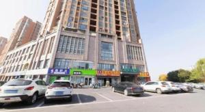 ChengdongにあるGreenTree Inn Lu'an Jin'an District Yuanda Xingfuliの駐車場に車が駐車されている大きな建物