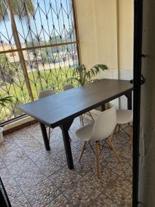 a black table and chairs in a room with a window at Amtwapa 2bedroom apartment in Mtwapa