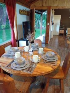 Una mesa de madera con platos y cuencos encima. en Cabaña sureña, en San Carlos de Bariloche 7 fotos más