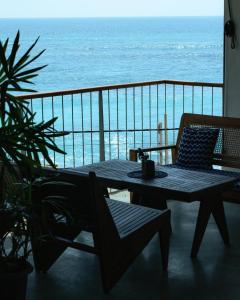 a table and chairs on a balcony with the ocean at UNU Boutique Hotel -- Adults Only -- in Ahangama