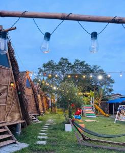 a view of a group of huts with lights at Người Giữ Rừng- Nhà hàng và Du Lịch Sinh Thái in Bình Ðại