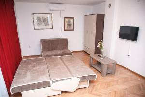 1 dormitorio con 1 cama grande y 1 mesa en Apartments Konak, en Visoko