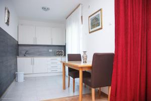 a kitchen with a table and chairs and a red curtain at Apartments Konak in Visoko