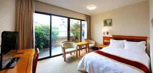 広州市にあるNanfang Dasha Hotelのベッドと机と窓のあるホテルの部屋