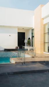 a building with a swimming pool in front of a building at Hummingbird Rak in Ras al Khaimah