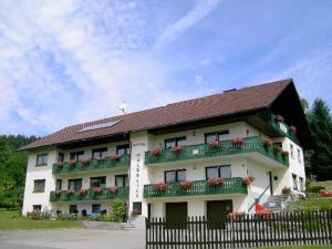 ein weißes Gebäude mit Balkonen und Blumen darauf in der Unterkunft Pension Waldblick in Bayerisch Eisenstein