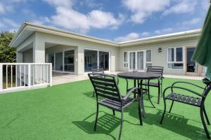 a patio with chairs and a table on a lawn at Gemmel Place Villa in Durban