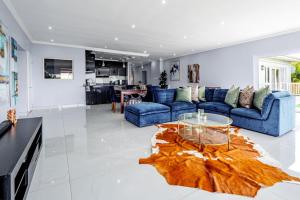 a living room with a blue couch and a glass table at Gemmel Place Villa in Durban