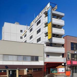 a tall white building with a hotel sign on it at Ueda Plaza Hotel in Ueda
