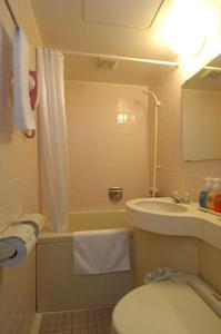 Un baño pequeño con inodoro y lavabo. en Matsumoto Wellton Hotel, en Koyanagichō