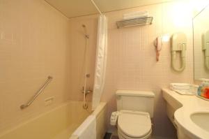 Un baño con inodoro, bañera y lavabo. en Matsumoto Wellton Hotel, en Koyanagichō 137 fotos más