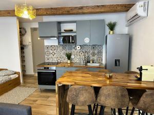 a kitchen and dining room with a wooden table and chairs at Mauguio Center Hôtel in Mauguio +48 photos