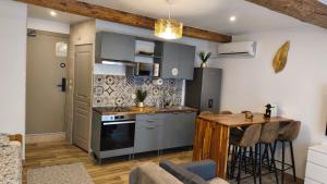 a kitchen with a counter and a table in a room at Mauguio Center Hôtel in Mauguio
