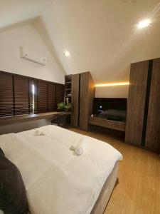 a bedroom with a large white bed with two towels on it at I-DIN POOL VILLA khaoyai in Ban Nong Song Hong