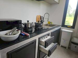 a kitchen with a counter with a sink and a stove at I-DIN POOL VILLA khaoyai in Ban Nong Song Hong