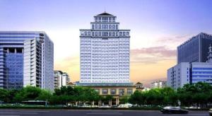 a large white building with a tower in a city at Chongqing Sunshine Continental Grand Hotel in Chongqing