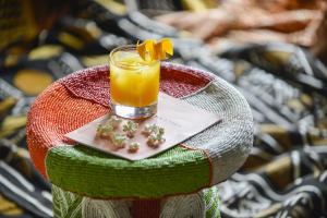 a glass of orange juice with a flower on a table at Ha(a)ïtza in Pyla-sur-Mer