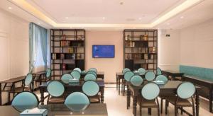 a classroom with tables and chairs in a room at Xana Lite·Nanchang Changbei Jiangxi University of Finance and Economics in Nanchang
